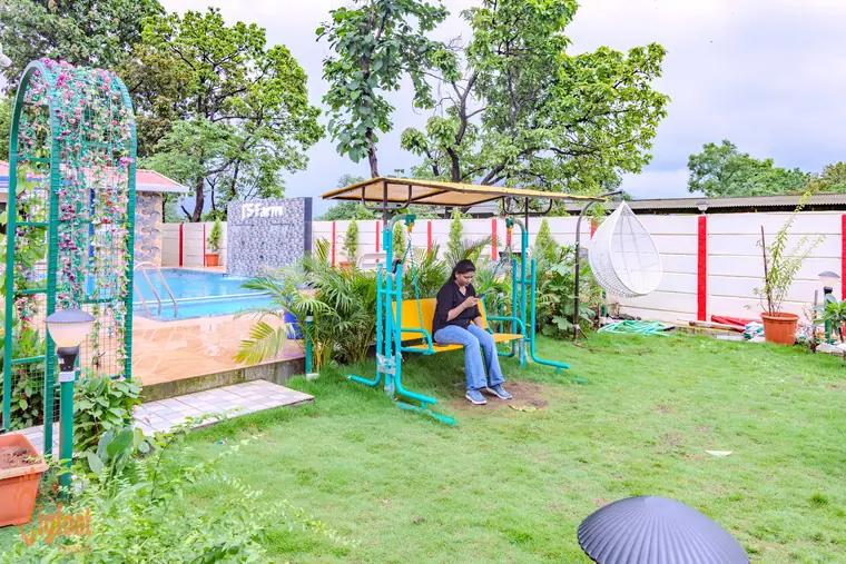Garden swing and hanging chair on the lawn at JS Farm Resort, Karjat