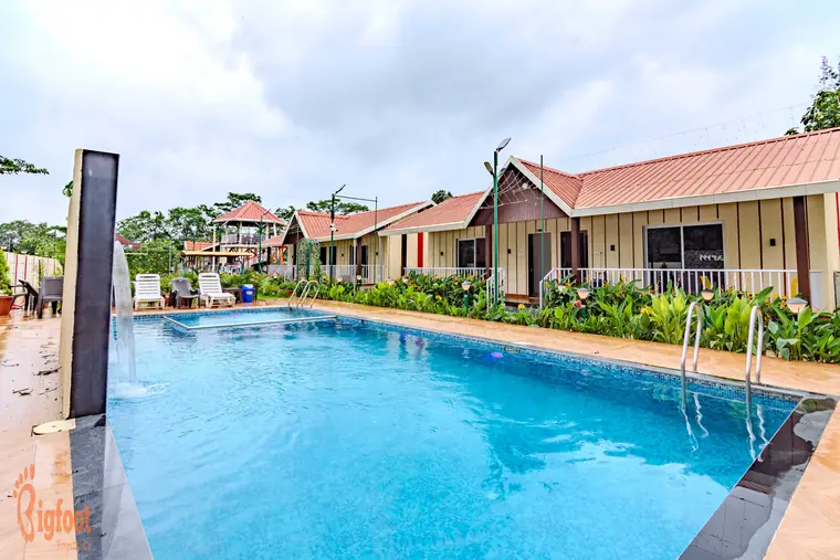 Poolside deck and lawn at JS Farm Resort, Karjat